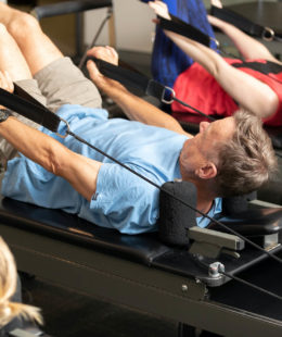 man using pilates reformer for exercise
