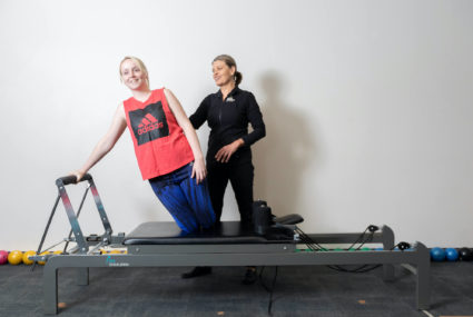 woman using clinical pilates reformer