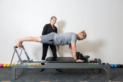 man stretching on pilates reformer
