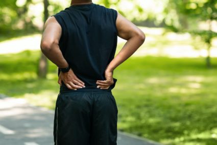 Black guy having back pain during his morning run at park